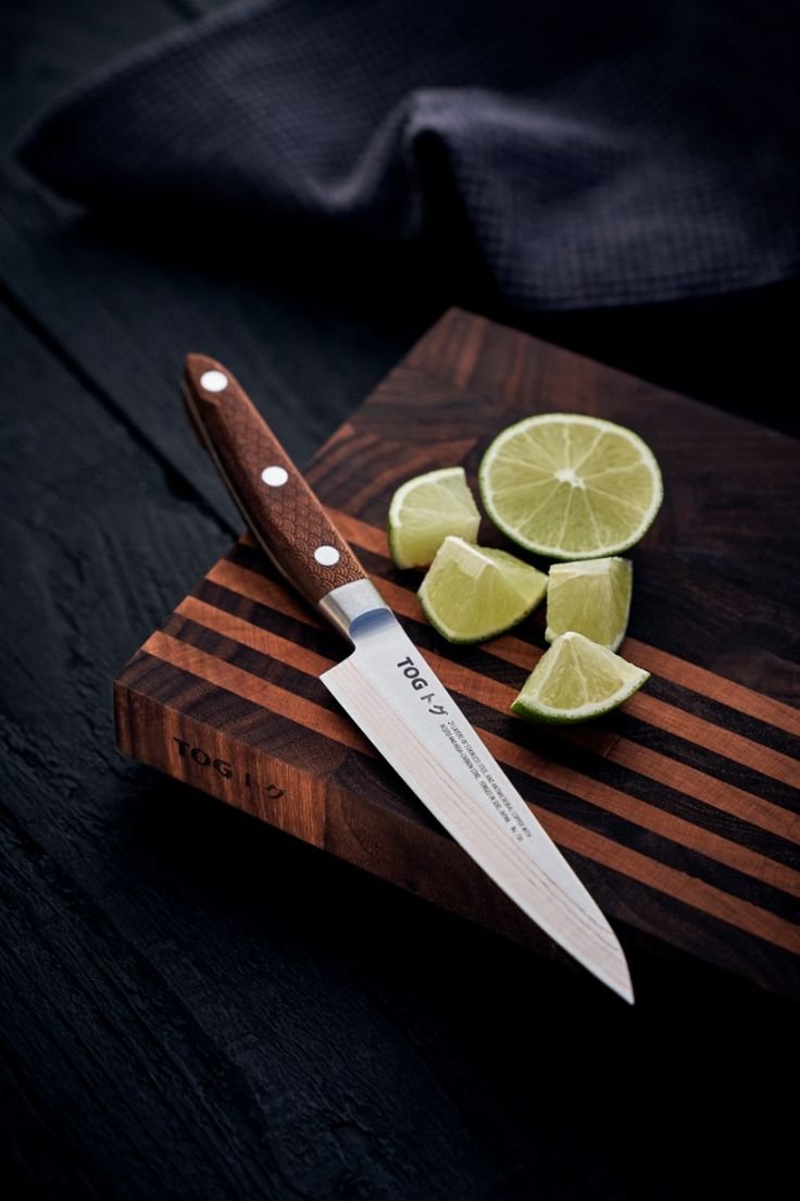 Damascus chef knife on a dark slate board